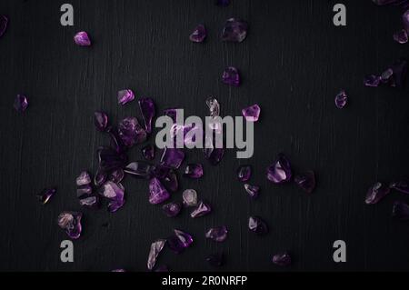 amethyst chips macro detail black background. close-up polished semi-precious gemstone top view copy space. Stock Photo