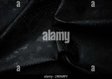 Vegan faux Snakeskin leather texture. minimalist and elegant crumple textile. simple dark black backdrop Stock Photo