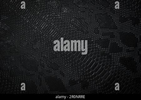 Vegan faux Snakeskin leather texture. minimalist and elegant crumple textile. simple dark black backdrop Stock Photo