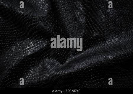 Vegan faux Snakeskin leather texture. minimalist and elegant crumple textile. simple dark black backdrop Stock Photo