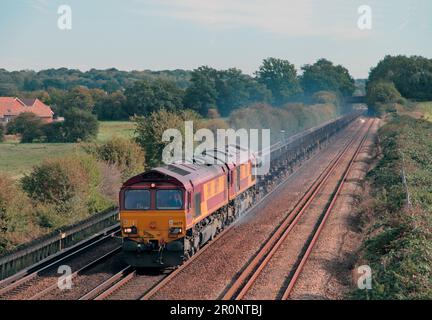 A pair of DB Cargo UK Class 66 diesel locomotives numbers 66079 and 66112 double heading empty steel wagons at Otford Junction in Kent. Stock Photo