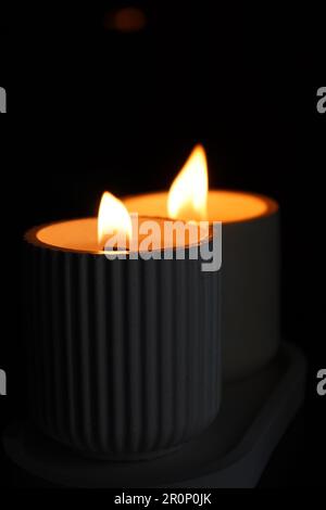 An aromatic candle burns in the dark and creates a romantic atmosphere. The fire is burning. A romantic candlelit dinner for two lovers. Romantic nigh Stock Photo