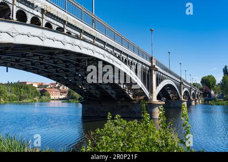 Perspective view of the Enrique Estevan bridge over the Tormes river in the city of Salamanca, with blue sky. Stock Photo