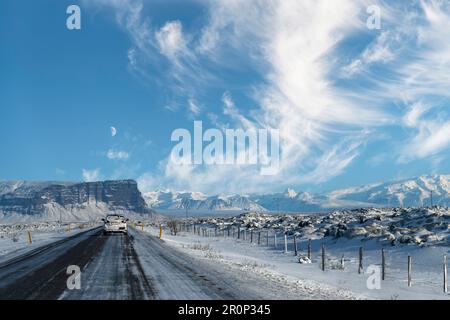 Driver’s perspective view over road route 1 of Iceland through a snowy mountainous landscape with view on first mountains of Vatnajokull National Park Stock Photo