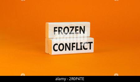 Frozen conflict symbol. Concept words Frozen conflict on beautiful wooden block. Beautiful orange table orange background. Business and Frozen conflic Stock Photo