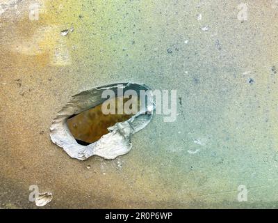 Shelled and pierced armor on a combat vehicle. Shrapnel-pierced armor of an infantry fighting vehicle. Tank armor slashed by shrapnel from a wrecked t Stock Photo