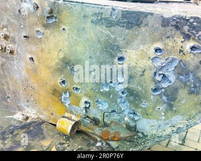 Shelled and pierced armor on a combat vehicle. Shrapnel-pierced armor of an infantry fighting vehicle. Tank armor slashed by shrapnel from a wrecked t Stock Photo