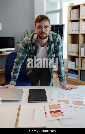 Solar energy project engineer leaning on desk with documentation Stock Photo