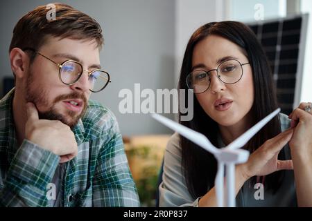 Engineers discussing model of new wind turbine Stock Photo