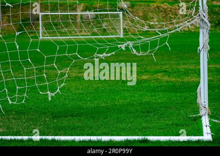 Worn out soccer net on goal used handing ratty and frayed netting Stock Photo