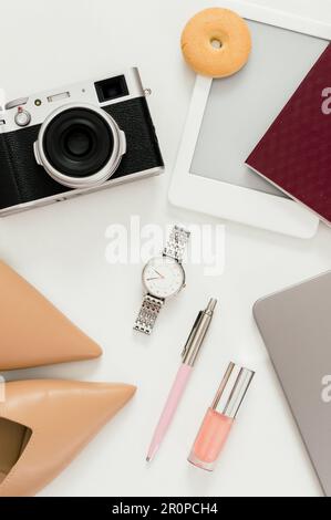 A flat lay of a woman's office desk, featuring a laptop, a notebook and various accessories Stock Photo