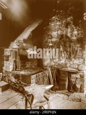 A sepia toned photograph taken on a paper negative on a 5 x 4 camera of the interior of the forge in 1976 in the Cotswold village of Great Barrington. Stock Photo