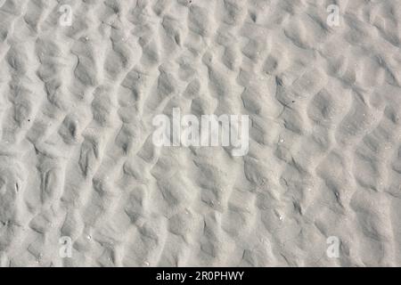 Chaotic pattern of ripples in the sand of the beach, caused by waves and the movement of water Stock Photo