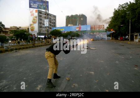 Police officials restore baton charge, fire tear gas and arrest to repel supporters of Tehreek-e-Insaf (PTI) during their protest demonstration against arrested of PTI Chairman Imran Khan in Islamabad, at Shahrah-e-Faisal road in Karachi on Tuesday, May 9, 2023. The arrest of ex-Prime Minister of Pakistan, Imran Khan outside the Islamabad High Court (IHC) resulted in protests and demonstrations by Pakistan Tehreek-e-Insaf (PTI) supporters across Pakistan. Protestors clashed with the police near Nursery. They threw stones at police vehicles and tore down street Stock Photo