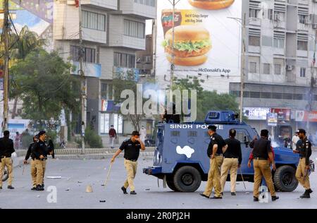 Police officials restore baton charge, fire tear gas and arrest to repel supporters of Tehreek-e-Insaf (PTI) during their protest demonstration against arrested of PTI Chairman Imran Khan in Islamabad, at Shahrah-e-Faisal road in Karachi on Tuesday, May 9, 2023. The arrest of ex-Prime Minister of Pakistan, Imran Khan outside the Islamabad High Court (IHC) resulted in protests and demonstrations by Pakistan Tehreek-e-Insaf (PTI) supporters across Pakistan. Protestors clashed with the police near Nursery. They threw stones at police vehicles and tore down street Stock Photo