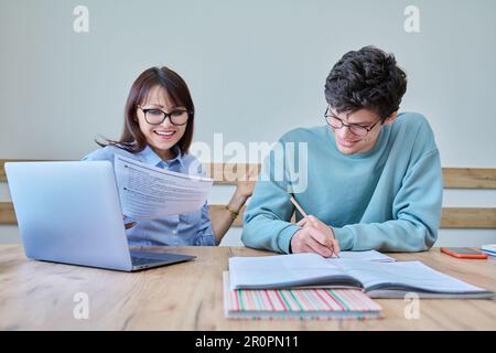 Young teenage male studying languages with teacher in classroom Stock Photo