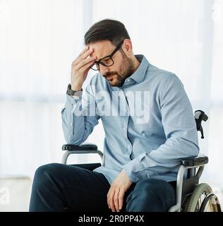 disability wheelchair disabled man handicap sitting handicapped health young wheel care invalid depressed lonely sad alone solitude worried Stock Photo