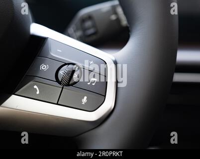 Buttons on the steering wheel, hands-free system, steering wheel controls. The concept of using technology in the car. Stock Photo