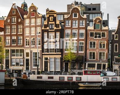 Famous and iconic Amsterdam houses under the morning sky. Various traditional houses in the historic center of Amsterdam. Amsterdam, North-Holland, Stock Photo