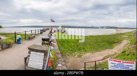 A multi image panorama of bunting on the pier at Arnside in Cumbria, seen on the day Charles III was crowned King, as a Union Jack flaps in the wind. Stock Photo