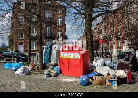 Unauthorized waste and trashes dump in the middle of a square and around the glass bootle bin and oil bin | Depôt clandestin de detritus, poubelles et Stock Photo