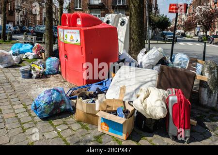 Unauthorized waste and trashes dump in the middle of a square and around the glass bootle bin and oil bin | Depôt clandestin de detritus, poubelles et Stock Photo