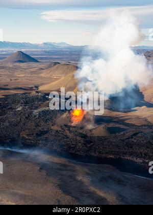 Aerial view of erupting volcano with smoke and clouds at sunset, Fuego ...