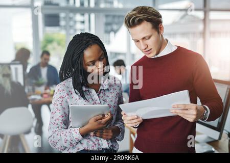 What do you make of this data. two young colleagues discussing paperwork together in a modern office. Stock Photo