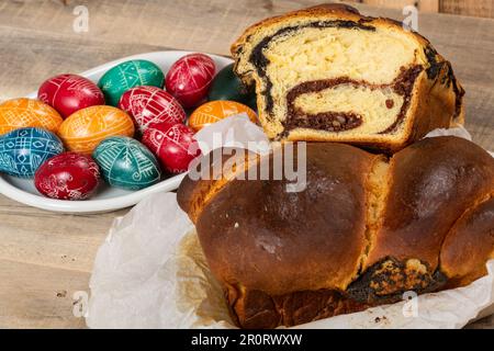 Freshly baked Romanian cakes and hand painted painted Easter eggs. "Cozonac" or "cozonaci", is made of sweet yeast dough used to make traditional holi Stock Photo