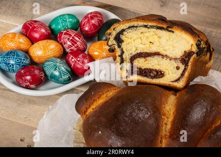 Freshly baked Romanian cakes and hand painted painted Easter eggs. "Cozonac" or "cozonaci", is made of sweet yeast dough used to make traditional holi Stock Photo