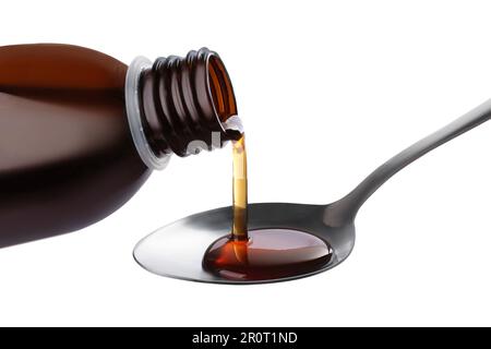 Pouring syrup into spoon from bottle isolated on white, closeup. Cough and cold medicine Stock Photo