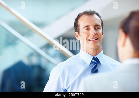 An office executive having conversation with his colleague. Portrait of an office executive having conversation with his colleague. Stock Photo