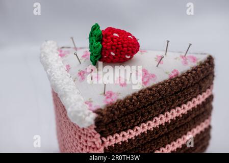 Chocolate and raspberry cake pincushion with a strawberry on top Stock Photo