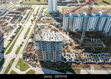 aerial view of big construction site with residential buildings under construction, cranes, equipment and building materials. Stock Photo