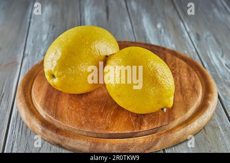Lemons on wooden stand on gray wooden background Stock Photo