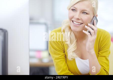 Im almost finished here at the office...an attractive young businesswoman talking on her cellphone. Stock Photo