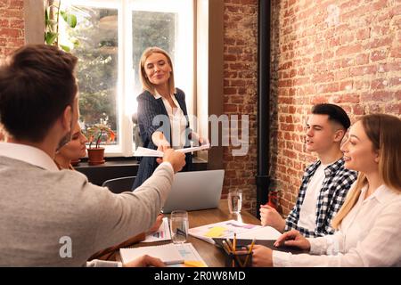Businesswoman having meeting with her employees in office. Lady boss Stock Photo