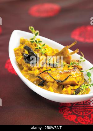 Rabbit with saffron rice and black trumpet mushrooms Stock Photo