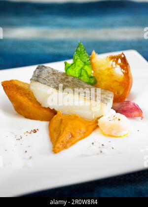 Thick piece of salt-cod with cream of red peppers Stock Photo