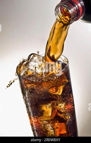 Pouring a glass of Coca-cola with ice cubes Stock Photo