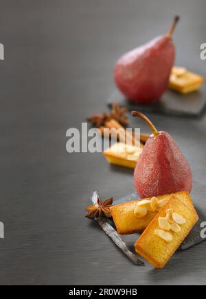 Pears poached in spicy wine, almond Financiers Stock Photo