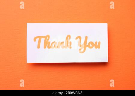 Note with phrase Thank You on orange background, top view Stock Photo