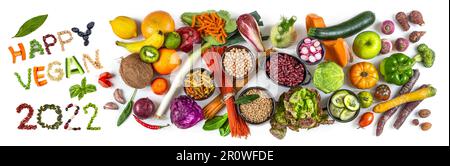 Happy vegan 2022' next to fruit, vegetables and cereals Stock Photo