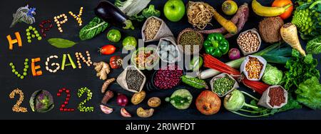Happy Vegan 2022' next to organic fruit, vegetables and cereals Stock Photo