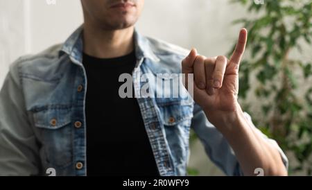 Sign language interpreter man translating a meeting to ASL, American Sign Language. Empty copy space for Editor's content Stock Photo