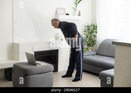 Gray-haired senior man doing online training on a laptop Stock Photo