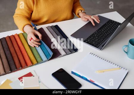High angle view of designer of interior using laptop while working with colored palette at her workplace Stock Photo