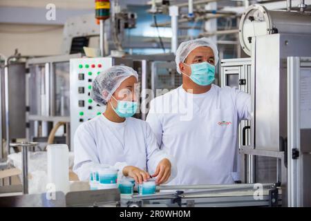 Almaty province, Kazakhstan - June 06, 2012: Amiran milk factory. Two operators on production line. Stock Photo