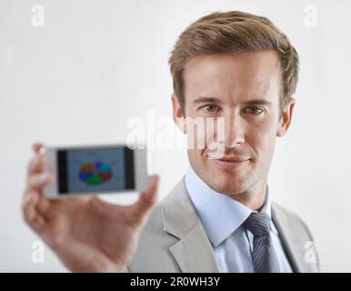 Its chart smart. A young businessman holding a piechart to the camera. Stock Photo