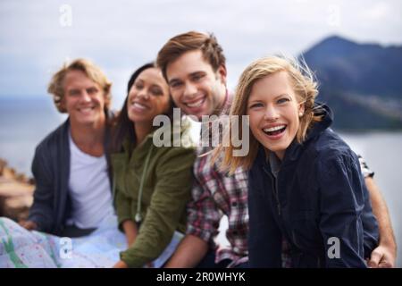 Gathered together on top of the world. A shot of a young group of friends on the side of the road during their road trip. Stock Photo